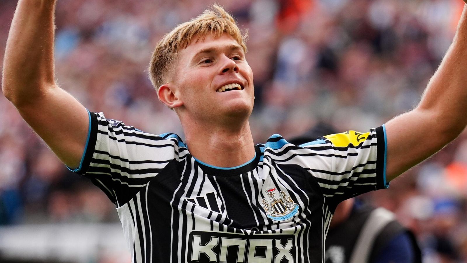 A Newcastle player celebrates with arms raised at St James’ Park